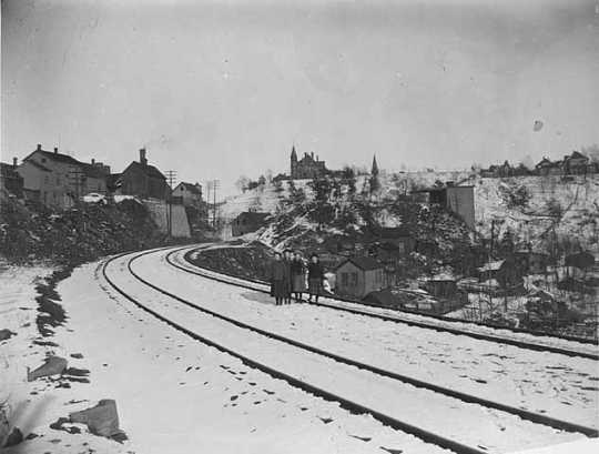 Black and white photograph of the Swede Hollow neighborhood taken from the St. Paul and Duluth Railroad tracks, c.1910.