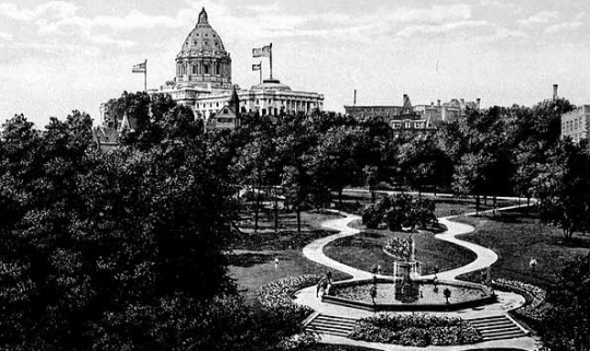 Tinted photographic postcard on paper. Its view faces northwest across Central Park toward the (then new) State Capitol, c.1915.