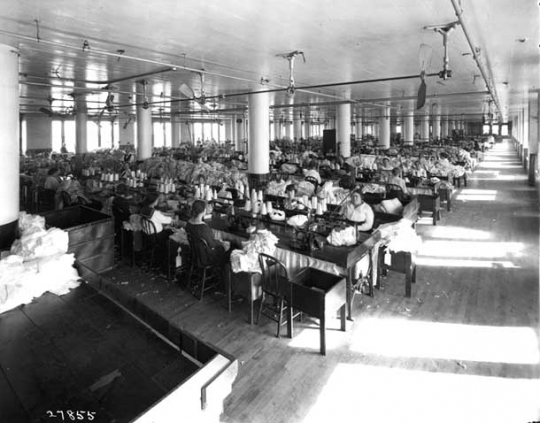 photograph of a room full of women at sewing machines