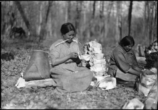 Photograph of Mary Bigwind and Maggie Skinaway making birch bark containers for maple sap