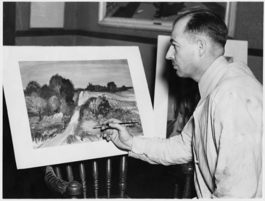 Black and white photograph of Cameron Booth posing with a watercolor, 1937.