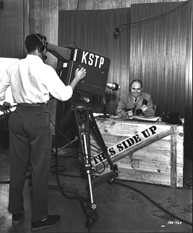 Black and white photograph of a KSTP-TV cameraman filming the This Side Up program, 1950.