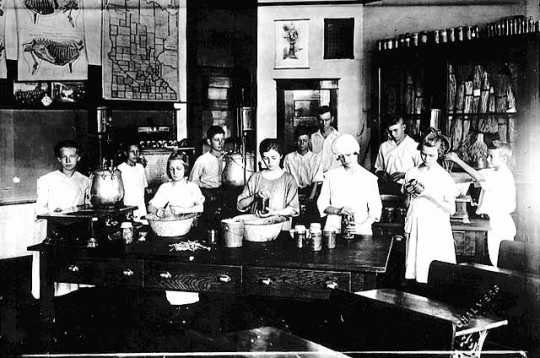 Black and white photograph of members of the Boys and Girls Club participating in a canning demonstration, 1920.