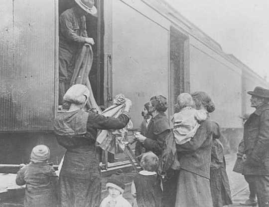 Black and white photograph of the National Guard giving out clothing to refugees, 1918. 