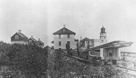 Black and white photograph of Split Rock Light Station and a tram car c.1916.