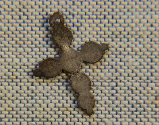 Color image of a silver cross pendant found at the Réaume site, 2012.