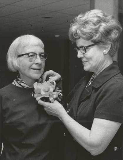 Black and white photograph of St. Catherine’s alumna Betty Hubbard (right) pinning a corsage on Alice Gustava Smith (Sister Maris Stella, left) at the College of St. Catherine in 1971. Photographed by P.J. Strasser. 