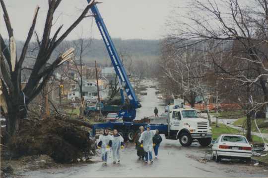 Photograph of volunteers clearing debris from a street in St. Peter. 