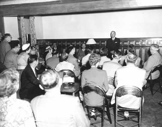Black and white photograph of former president Harry Truman speaks to guests in Nelson Hall, the post’s headquarters, in July 1953
