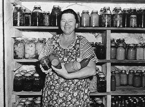Woman with canned vegetables, part of Farm Security Administration program. 