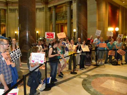 Color image of demonstrators gathered at the State Capitol in St. Paul to show their opposition to Minnesota Amendment 1. Photographed on May 20, 2011, by Flickr user Flickr user Fibonacci Blue.