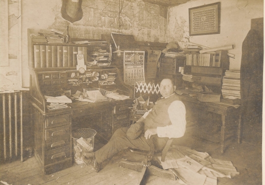 Black and white photograph of Waconia Patriot editor and publisher Charles Reil in his office, 1917.