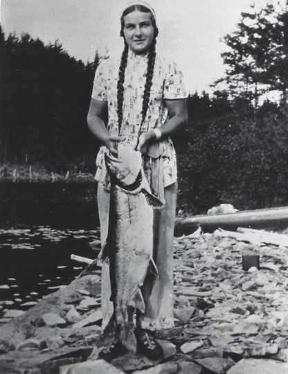 Black and white photograph of Dorothy Molter holding a lake trout, ca. 1940s.