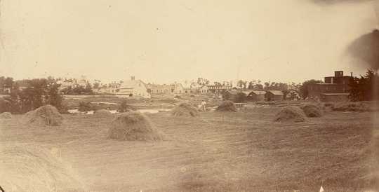 Black and white photograph of downtown Hanover seen from the Hennepin County side of the Crow River, ca. late 1800s.
