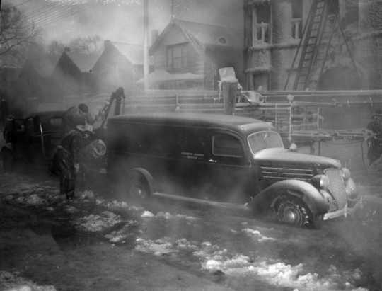 Photograph of Minneapolis firefighters trying to move a Hennepin County Morgue truck after being iced in during a January 3, 1940 fire at the Marlborough Apartment Hotel