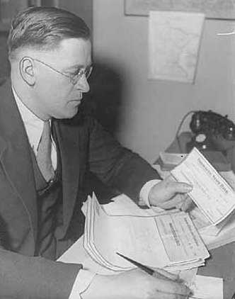 Black and white photograph of Elmer Benson at his desk, c.1934. Photographed by the St. Paul Daily News.