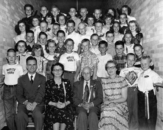 Black and white photograph of Edward F. Waite posed with students at Waite Park School, c.1955.