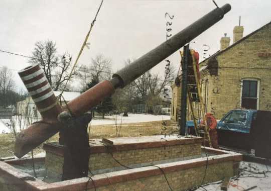 Color image of the world’s largest peace pipe, photographed during installation next to the Rock Island Depot in Pipestone, 1998. 