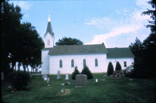 A side view of the Swedish Evangelical Lutheran Church, (Our Savior’s Lutheran Church), Ham Lake, including part of the cemetery. This image was originally a slide. Photographer and date unknown.